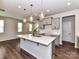 Bright, open kitchen with a large island, wood floors, stainless steel appliances, and access to the living area at 9134 Northfield Crossing Dr, Charlotte, NC 28269