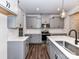 Modern kitchen featuring an island with a sink, gray cabinets, stainless appliances, and tile backsplash at 9134 Northfield Crossing Dr, Charlotte, NC 28269