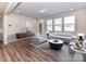 Bright living room featuring wood floors, modern furniture, and natural light from multiple windows at 9134 Northfield Crossing Dr, Charlotte, NC 28269