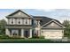 Charming two-story home featuring a welcoming front porch, attached two-car garage, and manicured lawn at 1015 Gardenia Dr # 52, Mt Ulla, NC 28125