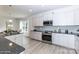 Bright kitchen featuring white cabinetry, stainless steel appliances and an open layout to the dining area at 1015 Gardenia Dr # 52, Mt Ulla, NC 28125