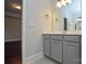 Bathroom showcasing a gray vanity with a white countertop, large mirror and neutral wall color at 10209 Meeting House Nw Dr, Huntersville, NC 28078