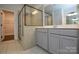 Bathroom featuring a tiled shower with glass doors and a gray vanity with a white countertop at 10209 Meeting House Nw Dr, Huntersville, NC 28078