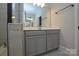 Bathroom featuring a gray vanity with a white countertop, large mirror, and tiled shower at 10209 Meeting House Nw Dr, Huntersville, NC 28078