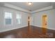Bright bedroom featuring tray ceiling, hardwood floors, and two large windows at 10209 Meeting House Nw Dr, Huntersville, NC 28078