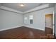 Bright bedroom with hardwood floors, tray ceiling, and large windows at 10209 Meeting House Nw Dr, Huntersville, NC 28078