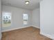Bedroom with neutral carpet, white trim, and two windows overlooking the neighborhood at 10209 Meeting House Nw Dr, Huntersville, NC 28078