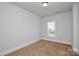 Bedroom with neutral carpet, white trim, and one window overlooking the neighborhood at 10209 Meeting House Nw Dr, Huntersville, NC 28078
