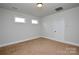 Bedroom with neutral carpet, white trim, and two windows at 10209 Meeting House Nw Dr, Huntersville, NC 28078