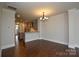 Bright dining room features hardwood floors and chandelier lighting, open to kitchen area with modern finishes at 10209 Meeting House Nw Dr, Huntersville, NC 28078