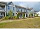 Attractive townhome exterior featuring covered entrances, tidy landscaping, and inviting curb appeal at 10209 Meeting House Nw Dr, Huntersville, NC 28078