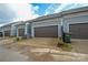 Attached garages of gray townhomes featuring brown garage doors at 10209 Meeting House Nw Dr, Huntersville, NC 28078
