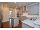 Modern kitchen with grey cabinets, granite countertops, stainless appliances, and island at 10209 Meeting House Nw Dr, Huntersville, NC 28078