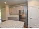 Kitchen features stainless steel refrigerator and grey cabinets with granite countertops at 10209 Meeting House Nw Dr, Huntersville, NC 28078