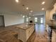 Open-concept kitchen featuring a large island with a sink, granite countertops, and modern appliances at 1050 Gardenia Dr # 3, Mt Ulla, NC 28125