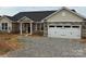 Charming single-story home featuring stone accents, a front-facing two car garage, and a manicured gravel driveway at 1070 Gardenia Dr # 4, Mt Ulla, NC 28125
