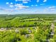 Gorgeous aerial view showcases homes nestled among green landscapes, a tranquil lake, and a clear blue sky at 108 Castleview Ln, Mooresville, NC 28115