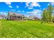 Spacious backyard with a green lawn, a patio area, and neighboring houses in a residential community at 108 Castleview Ln, Mooresville, NC 28115