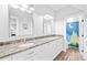 Well-lit bathroom with dual sinks, granite countertops, and a shower with a fun shower curtain at 108 Castleview Ln, Mooresville, NC 28115