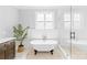 Elegant bathroom featuring a standalone tub, a large window, and a glass-enclosed shower at 108 Castleview Ln, Mooresville, NC 28115