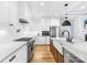 Open kitchen design with white cabinets, stainless steel appliances, butcher block island, and white subway tile backsplash at 108 Castleview Ln, Mooresville, NC 28115