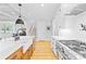 Bright kitchen features an island with sink, white countertops, stainless appliances, and hardwood flooring at 108 Castleview Ln, Mooresville, NC 28115