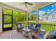 Inviting screened porch with wicker furniture and serene views of the lush green landscape at 108 Castleview Ln, Mooresville, NC 28115
