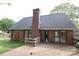 Rear exterior view featuring a brick chimney and wooden deck at 1121 Thoroughbred Nw Pl, Concord, NC 28027