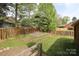 Backyard with a split rail fence, mature trees and a terraced planting bed at 1121 Thoroughbred Nw Pl, Concord, NC 28027