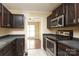 Kitchen with stainless steel appliances and dark wood cabinets at 1121 Thoroughbred Nw Pl, Concord, NC 28027