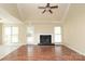 Living room with fireplace, ceiling fan, and large windows, offering natural light and warmth at 1121 Thoroughbred Nw Pl, Concord, NC 28027