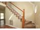 Carpeted staircase with wooden railings leads to the upper level, offering a classic design at 1121 Thoroughbred Nw Pl, Concord, NC 28027