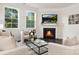 Bright living room featuring a cozy fireplace, large windows offering scenic views, and stylish contemporary furniture at 114 S Shayna Rd, Troutman, NC 28166