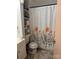 Cozy bathroom featuring a shower with a floral shower curtain and built-in shelving for storage at 1203 N Charlotte Ave, Monroe, NC 28110