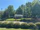 Charming one-story home set amongst mature trees, featuring a classic front porch design and welcoming curb appeal at 1203 N Charlotte Ave, Monroe, NC 28110