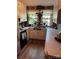 Traditional kitchen with white cabinets, cozy curtains, and a window with indoor plants at 1203 N Charlotte Ave, Monroe, NC 28110