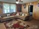 Comfortable living room featuring a large brown couch, patterned rug, and paneled walls at 1203 N Charlotte Ave, Monroe, NC 28110