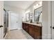 Bathroom featuring double sink vanity with granite countertop, dark cabinetry, mirrors, tile floors and a walk-in shower at 124 Rosebay Dr, Mooresville, NC 28117