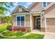 Home exterior with a stone accent, beautiful landscaping, and a well-lit front entrance at 124 Rosebay Dr, Mooresville, NC 28117