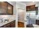A kitchen featuring granite countertops, dark cabinetry, stainless steel refrigerator, and a walk-in pantry at 124 Rosebay Dr, Mooresville, NC 28117