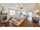 Open-concept living room featuring a fireplace, hardwood floors, and abundant natural light at 124 Rosebay Dr, Mooresville, NC 28117