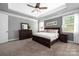 Elegant main bedroom featuring tray ceiling, ceiling fan, and dark wood furniture set at 12942 Blakemore Ave, Huntersville, NC 28078