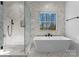 A bright bathroom showcases a marble-tiled shower and soaking tub underneath a window at 13453 Portside Ln, Lancaster, SC 29720