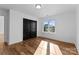 Bedroom featuring hardwood floors, window, and closet with black doors at 13453 Portside Ln, Lancaster, SC 29720
