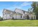Rear exterior view showcasing a modern farmhouse design with a covered back porch and fireplace at 13453 Portside Ln, Lancaster, SC 29720