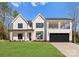 Beautiful two-story modern farmhouse featuring a black garage door and spacious front lawn at 13453 Portside Ln, Lancaster, SC 29720