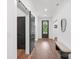 Inviting hallway featuring hardwood floors, black framed doors, a bench, and ample natural light at 13453 Portside Ln, Lancaster, SC 29720