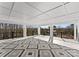 A large porch with decorative tile flooring, white columns, and a view of the surrounding trees and lake at 13453 Portside Ln, Lancaster, SC 29720