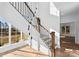Elegant staircase with wood and iron railing, and natural light from large windows at 13453 Portside Ln, Lancaster, SC 29720