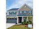 Two-story home features a brick facade, gray siding, a two-car garage, and a well-manicured lawn at 13748 Roderick Dr # 174, Huntersville, NC 28078